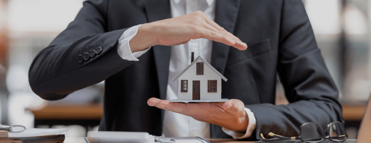An image of a hand gently cradling a miniature house, symbolising the financial security and asset protection benefits of setting up a family trust.